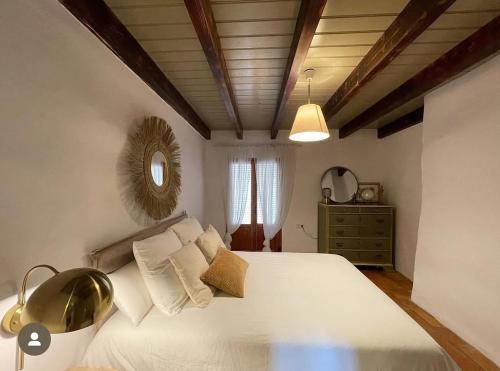 a bedroom with a large white bed and a mirror at Halona Casa Rural in Bullas