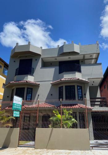 a house with a fence in front of it at Pousada Canasvieiras in Florianópolis
