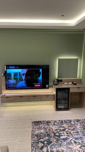 a living room with a large flat screen tv on a wall at استديو حديث دخول ذاتي وموقف خاص in Dammam