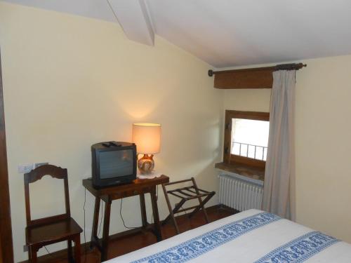 a bedroom with a bed and a tv and a chair at Lo Spedalicchio in Bastia Umbra