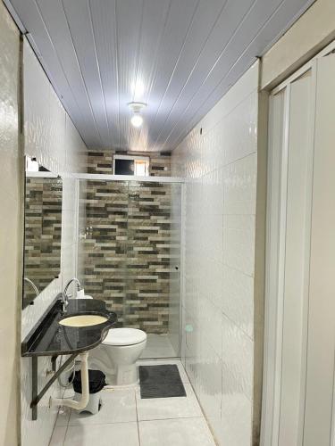 a bathroom with a toilet and a sink and a shower at Cantinho do Romeu in Soure