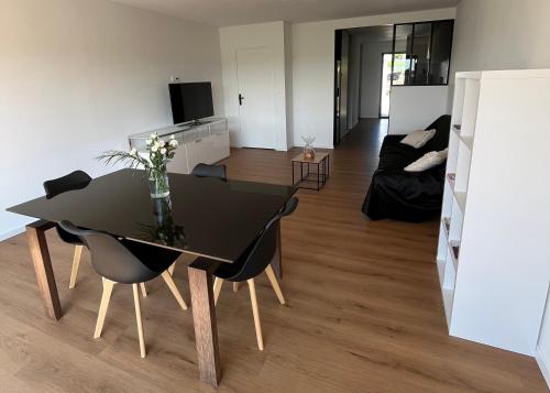 Noyal-PontivyLa villa Pontivyenne的客厅配有黑色餐桌和椅子