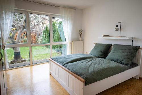 ein Schlafzimmer mit einem Bett und einem großen Fenster in der Unterkunft Am Feigenbaum in Albisheim