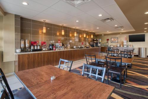 a restaurant with wooden tables and chairs and a bar at Best Western PLUS Fox Creek in Fox Creek