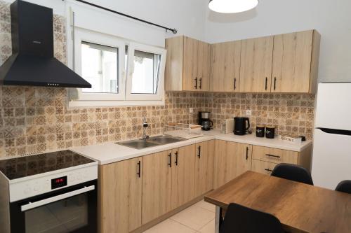 a kitchen with wooden cabinets and a sink and a table at Santa Marina 9 In the center of Ioannina! in Ioannina