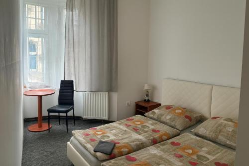 a bedroom with a bed and a table and a chair at Loftel v centru Ostravy in Slezská Ostrava