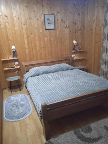 Un dormitorio con una cama y dos mesitas de noche. en Карпатські ночі, en Yaremche