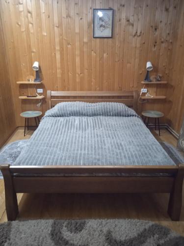 Un dormitorio con una cama con dos mesas dentro. en Карпатські ночі, en Yaremche