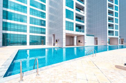 a swimming pool in front of a tall building at Luxury Sea View Apartment Pool & Gym&jacuzzi in Ajman