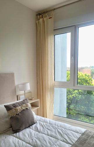 a bedroom with a bed and a large window at Cala in Olavarría