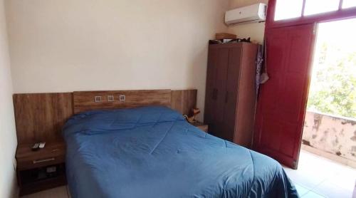 Un dormitorio con una cama azul y una ventana. en Zona Estadio Azulgrana para concierto de Shakira, en Asunción