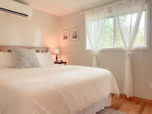 een slaapkamer met een wit bed en een raam bij Paradise Creek Cottage in Moscow