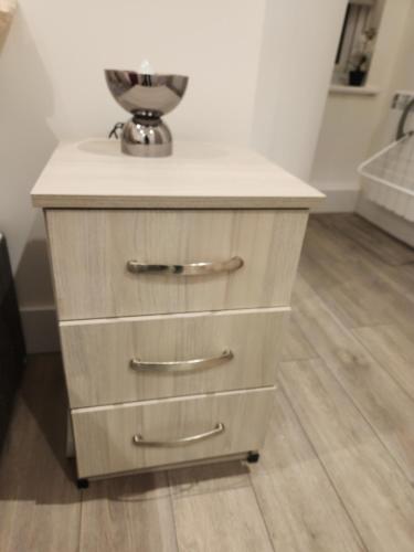 a wooden dresser with a bowl on top of it at Oxford Central city apartment in Oxford