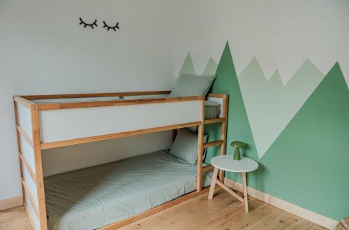 a bunk bed in a room with a table at Sur la Colline in Houffalize
