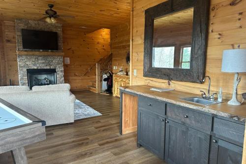 a kitchen and living room with a fireplace in a log cabin at View-Topia STUNNING VIEWS - Hot tub - Gameroom in Blue Ridge