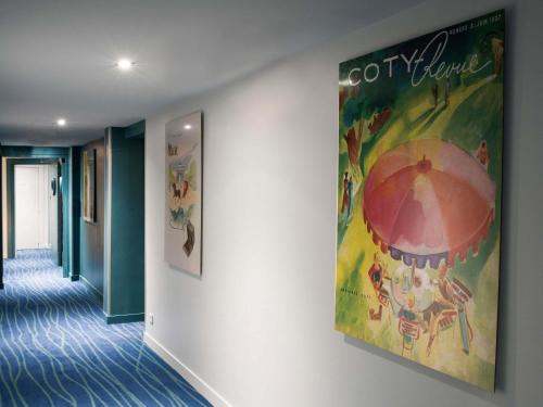 una gran pintura en la pared de un pasillo en Hôtel Mercure Paris Suresnes Longchamp, en Suresnes