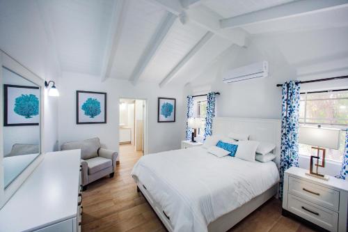 una camera da letto bianca con un letto e una sedia di Stunning 4 bedroom villa a Saint John's