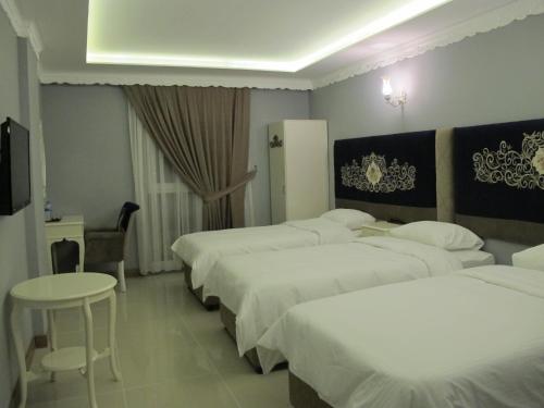a hotel room with four beds and a table at Kaya Palas Hotel in Kırklareli