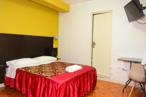 a hotel room with a bed with a red blanket at Hotel Casa Real Tacna in Tacna