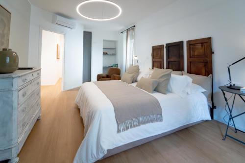 een witte slaapkamer met een groot bed en een dressoir bij Blue chic Suite CentroBergamo in Bergamo