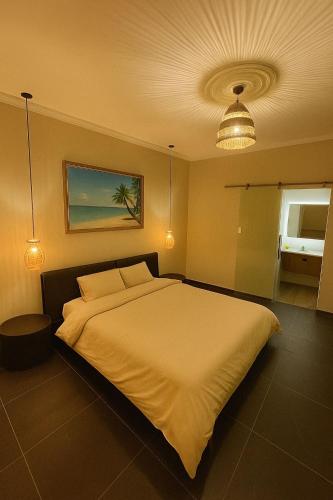 a bedroom with a large white bed and a light at درة العروس - فن بيتش in Durat Alarous