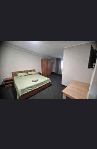 a bedroom with a bed and a wooden table at Bașcov S&D in Calafat