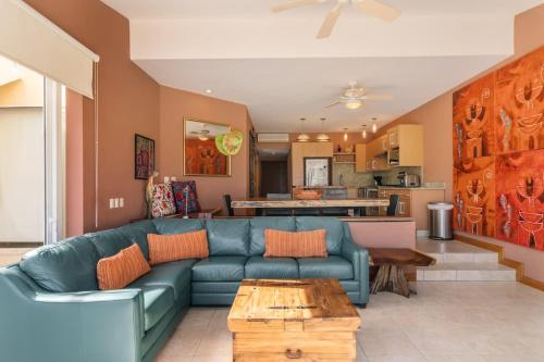 un soggiorno con un divano blu e un tavolo di Faro de Mita four bedroom Luxury Condo Walk to Town a Punta Mita