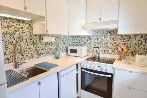a kitchen with white cabinets and a sink at NEW AC 1 Bedroom w Private Deck & Patio in Provincetown
