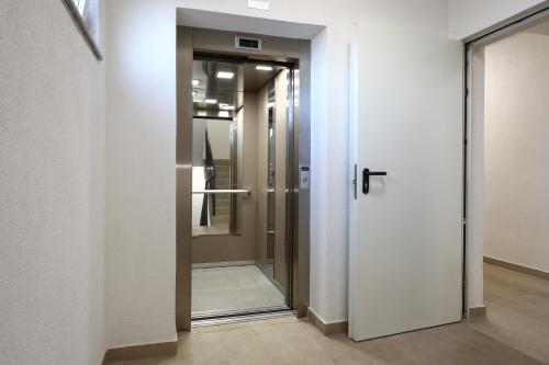 a corridor with a glass door in a building at Kosta Boutique Apartment in Banja Luka