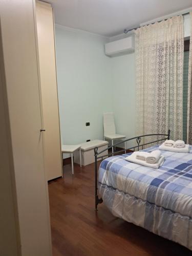 a bedroom with a bed with a blue comforter at Roses house in Porto San Giorgio