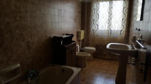 a bathroom with a toilet and a sink and a tub at Tra L'Etna e il Mare in Giarre