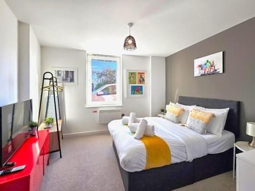 a bedroom with a large bed and a flat screen tv at The Post House One by Fortuna Property Portfolio in Gloucester