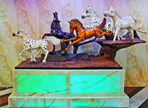 a statue of a group of horses on a stand at Bahrain International Hotel in Manama