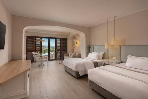 The Westin La Quinta Golf Resort & Spa, Benahavis, Marbella في مربلة: غرفة فندقية بسريرين وغرفة معيشة