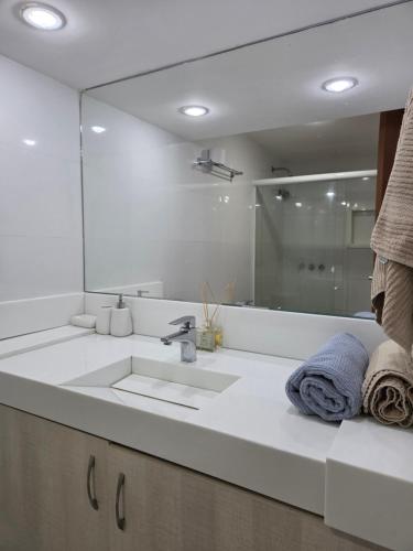 een badkamer met een wastafel en een spiegel bij Flat Sol Victoria Marina Vista Mar in Salvador