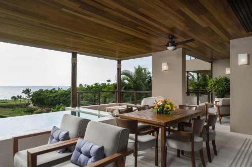 een eethoek in de buitenlucht met een houten tafel en stoelen. bij Tropical Oceanview Condo Punta Mita in Punta Mita