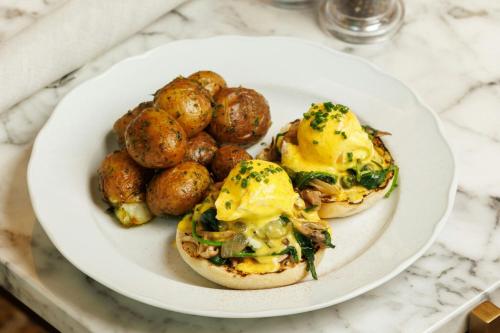 a plate of food with eggs and potatoes on a table at The Pearle Hotel & Spa, Autograph Collection in Burlington