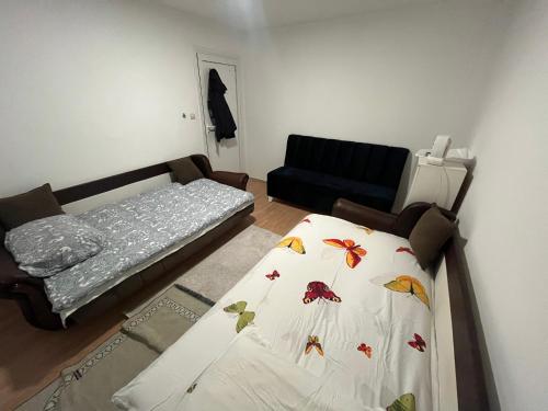 una pequeña habitación con una cama y un sofá en Apartmani Classic NP, en Novi Pazar