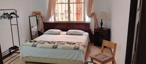 Un dormitorio con una cama y una ventana en Chambre paisible et romantique, en Tánger