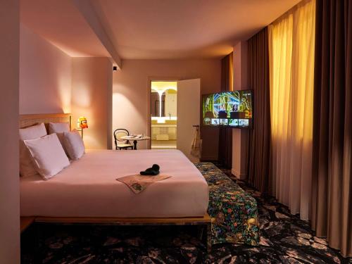 a hotel room with a bed and a television at Mama Shelter Roma in Rome