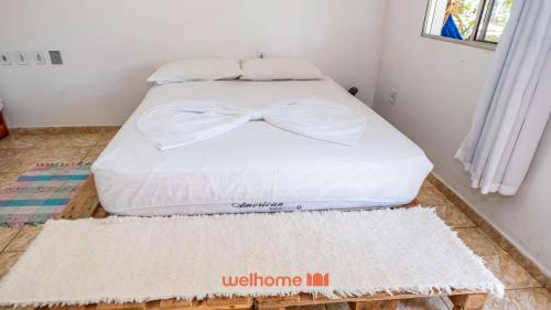 ein Schlafzimmer mit einem Bett mit einer Fliege darauf in der Unterkunft Pouso da Pardoca in Santa Cruz