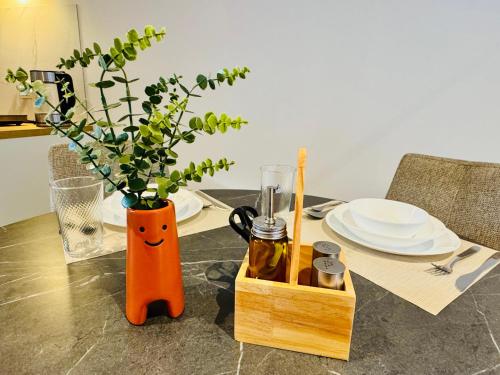 a table with a vase with a face drawn on it at Stylish private-entrance studio with bath and shower near Nijmegen Centre and Arnhem Zuid in Nijmegen