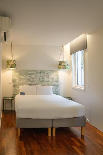 a bedroom with a white bed and a window at Oporto Riverside Rooftop in Porto