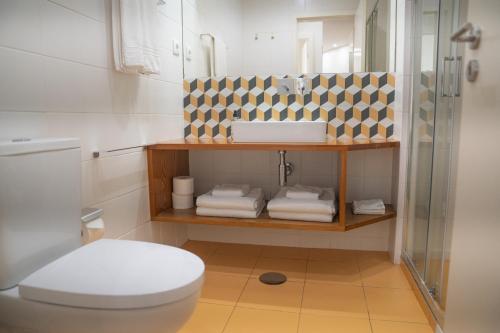 a bathroom with a shower and a toilet and towels at Oporto Riverside Rooftop in Porto