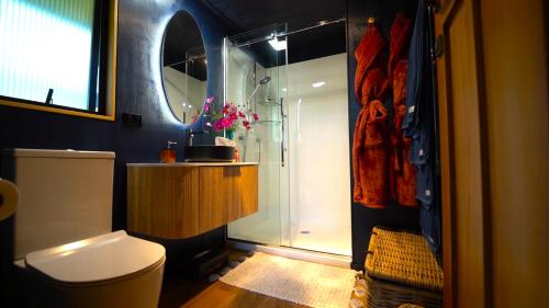 Un baño con ducha, inodoro y lavabo. en Ripples Retreat - Riverside Luxury, en Piopio