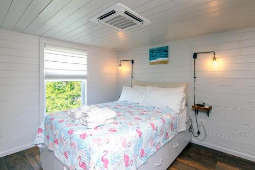 Un dormitorio con una cama con sábanas blancas y una ventana. en Marysol Cottage, en Edisto Beach