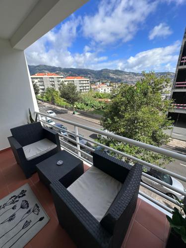 a balcony with couches and a view of a city at Heart of Madeira Island in Funchal