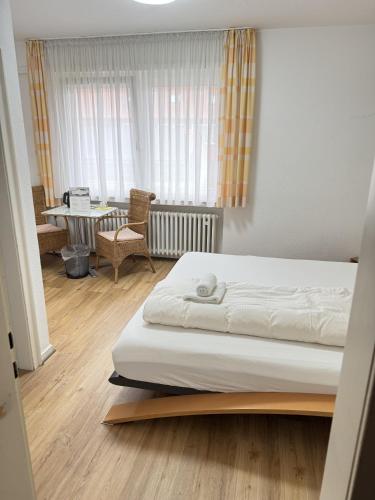 ein Schlafzimmer mit einem Bett, einem Schreibtisch und einem Tisch in der Unterkunft Hotel Wolbeck in Münster
