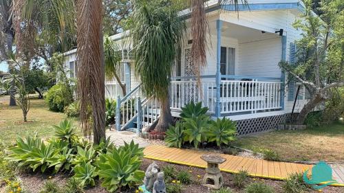una casa blu con un portico con alberi e piante di Bromyard Cottage a Swansea
