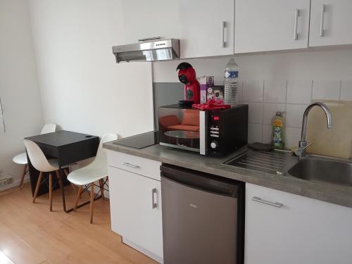 una cucina con un piano di lavoro con un forno a microonde di Lille Centre gare Lille Europe a Lille